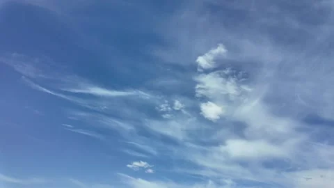 Soft clouds drift across a vast blue sky Video stock 335662026