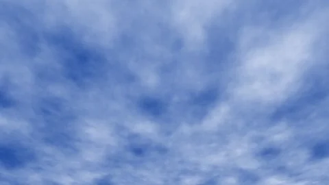 Soft clouds drift across a vast, serene blue sky Video stock 345421172