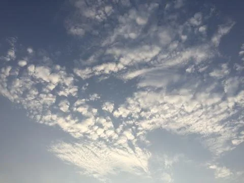 Soft Clouds Drifting Across a Blue Sky at Sunset Stock Photos