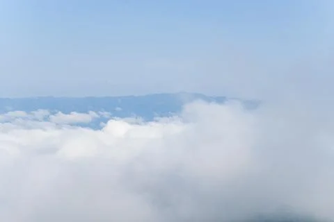 Soft clouds drifting over distant mountains Stock Photos