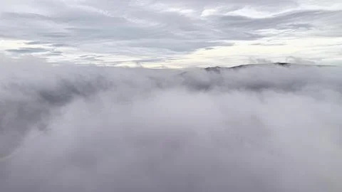 Soft Clouds Spread Across Sky, Serene Mist Covers Land Beneath Gentle Cloud.. Stock Photos