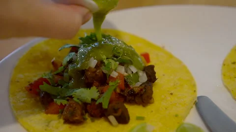 Soft corn tortilla taco hand eating salsa green jelapeno sauce Mexican food h Stock Footage 306220426