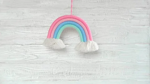 Soft Cotton Rainbow Toy Spinning against a Wooden White Wall. Stock Footage 238527689