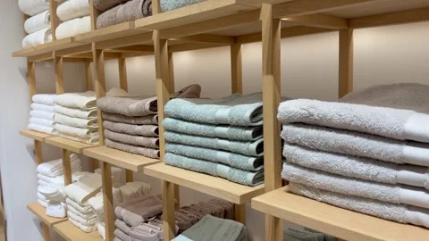 Soft cotton towels stacked in rows on wooden shelves create calm minimalist Stock Footage 334318204