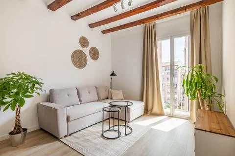 Soft couch and low table in living room with balcony door 스톡 사진