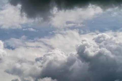 Soft cumulus clouds drift across blue, voluminous white formations, gentle su Stock Photos