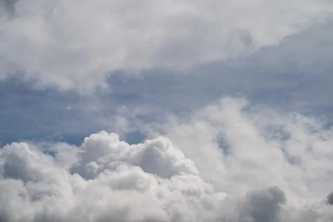 Soft cumulus clouds under pale sky, photographer framing gentle light and air Stock Photos