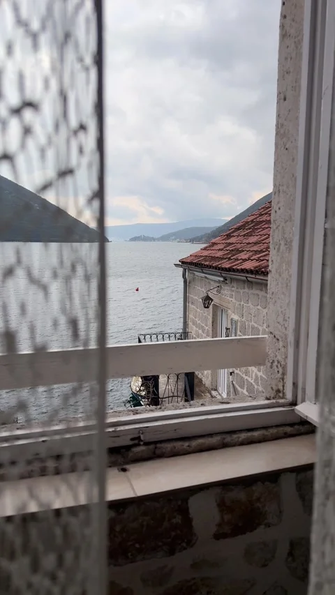 Soft curtains moving in the wind near open window with sea view in Mediterranean Stock Footage 332404085