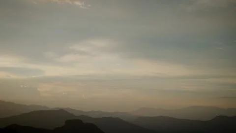 Soft dawn light over distant mountain silhouettes Stock Footage 316797366