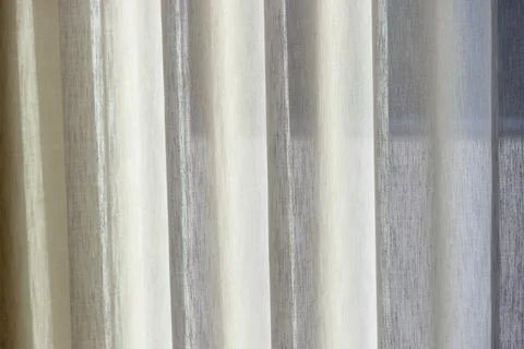 Soft daylight filtering through sheer pearl colored curtain fabric Stock Photos