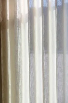 Soft daylight filtering through sheer pearl colored curtain fabric Foto stock