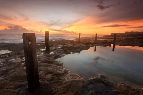 Soft diffused sunrise light at coastal rock pool 스톡 사진