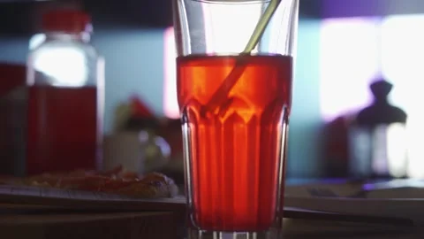 A soft drink and a straw in a clear glass, on a table in a cafe Video stock 252249913
