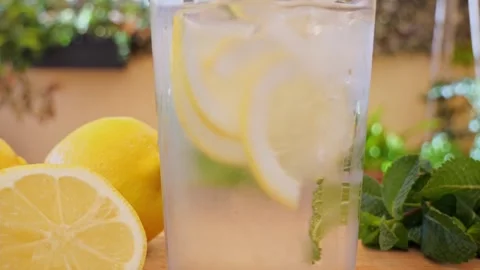 Soft Drink with Ice, Bubbles, Mint and lemon in glass. Outdoors Stock Footage 274665866