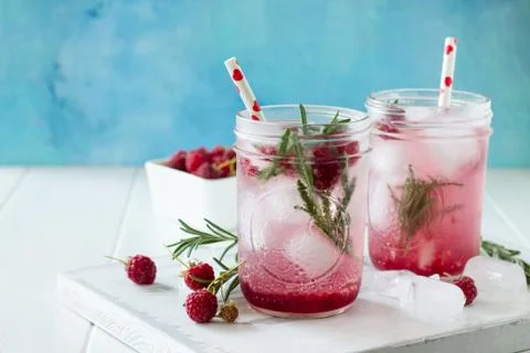 Soft drinks. Refreshing summer drink raspberry with rosemary and ice. Stock Photos