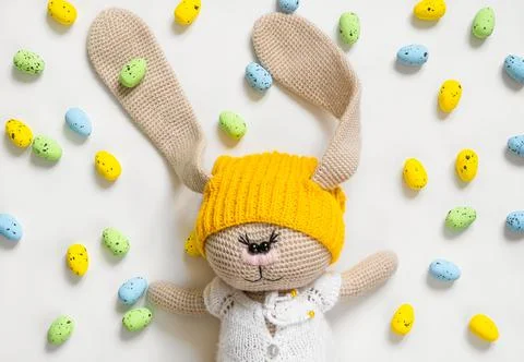 Soft easter bunny toy and lots of colorful eggs around Stock Photos