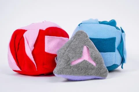 Soft educational toy for a child in the shape of a ball, pyramids and squares on Stock Photos