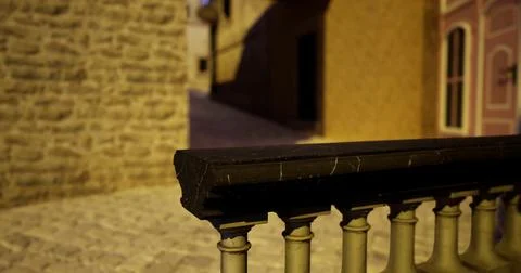 Soft evening light illuminates cobblestone street with stone walls Ilustración de archivo