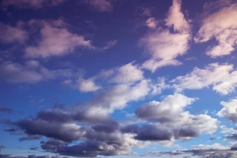 Soft evening sunlight on cumulus clouds in the sky Stock Photos