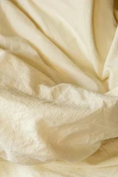 Soft fabric draped in natural light on a surface in a warm toned space duri.. Stock Photos