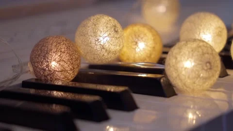 Soft Fading Garland String Lights on White Piano Keys 4K Stock Footage 339523455