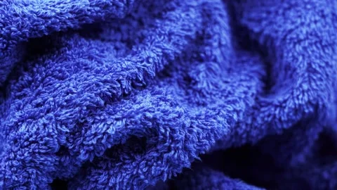 Soft fluffy terry towel of navy blue colour lies and rotates Stock Footage 138501394