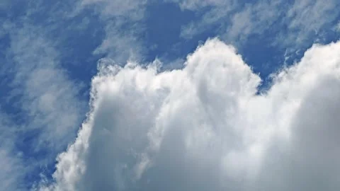 Soft fluffy white clouds drifting across a vibrant blue summer sky Stock Footage 340383145