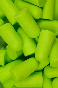 Soft foam ear plug..Lots of light green earplugs, close-up.Vertical photo Stock Photos