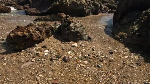 Soft, foamy ocean waves crashing into the rocks and sand of the beach Stock-Footage 319803054