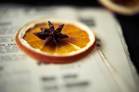 Soft focus background with orange and star anise on the top on vintage newspa Stock Photos