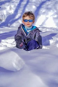 Soft focus background. Young Boy With Sunglasses Playing In The Snow Stock Photos