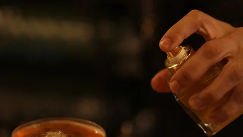 Soft Focus of Bartender Spraying Aromatic Essence on Cocktail Stock Footage 129782380