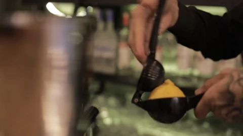 Soft Focus of Bartender Squeezing Orange for Cocktail Stock Footage 129832166