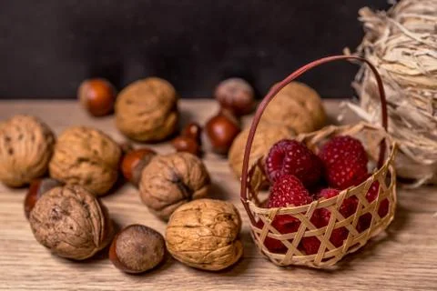 Soft focus, blurring background. Hazelnuts and walnuts. Raspberry wicker basket Stock Photos