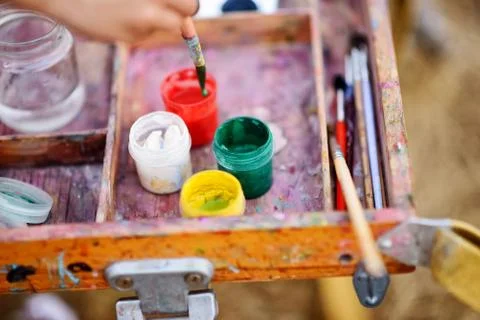 Soft focus. children's hands of the future artist, paint palette brushes, dif Stock Photos