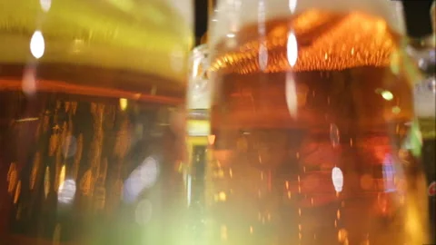 Soft focus, close-up. The gas bubbles rise up the glass of ale. Real-time, eveni Video stock 87426131