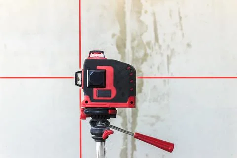 Soft focus. construction site. Red laser level, on a tripod. turned on in a d Stock Photos