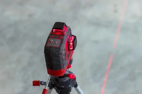 Soft focus. construction site. Red laser level, on a tripod. turned on in a d Stock Photos