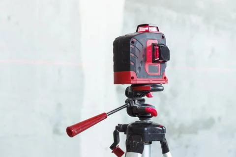 Soft focus. construction site. Red laser level, on a tripod. turned on in a d Stock Photos