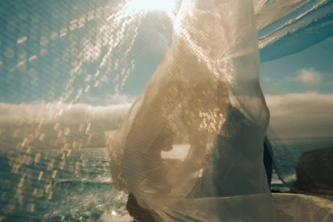 Soft focus. Couple in light attire enjoys the ocean view while standing on a Stock-Fotos
