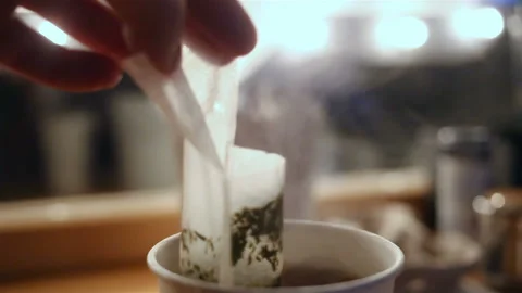 Soft focus on a Cup of steaming hot drink. Cup, fingers and bag close-up, real t Stock Footage 131512681