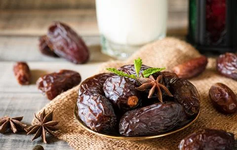 Soft focus of dates fruit on dark wooden background. Muslim simple Iftar conc 스톡 사진