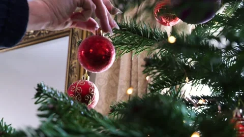 Soft Focus of Decorating a Twinkling Christmas Tree with Red Baubles, 4K Stock Footage 229504283