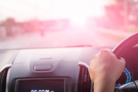 Soft focus driver hand holding steering wheel while driving on the road. Stock Photos