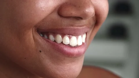 Soft focus on the glossy lips of an attractive young woman spreading into a Stock Footage 201879051