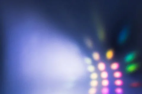 A soft-focus grid of colored lights beams across a deep blue background, cr.. Stock Photos