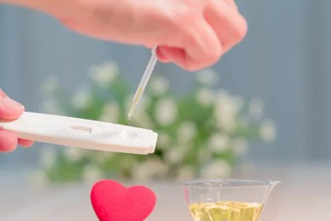 Soft focus on the pregnancy test process with red heart shape Stock Photos