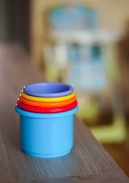 Soft focus shot of a stack of colorful plastic toy cups on a wooden table 库存照片