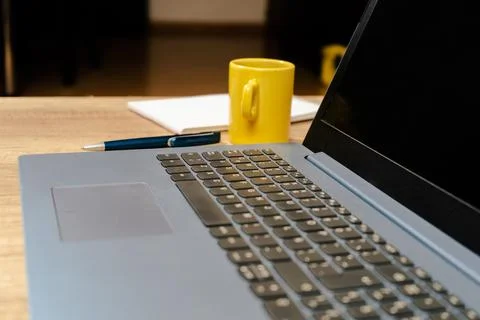 Soft focus of a Spanish version laptop keyboard next to a coffee and a pen in Stock Photos