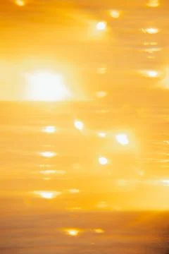 Soft focus. Sunset over ocean waves at beach with golden reflections during l Stock Photos